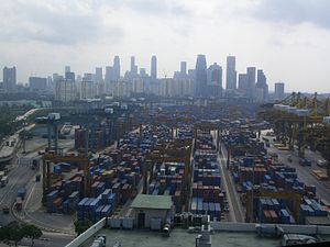 The port of Singapore with a large number of shipping containers with the skyline of the city visible in the background